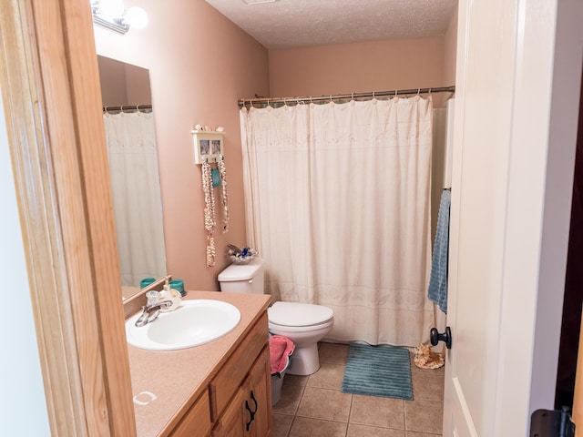 bathroom with toilet, tile patterned floors, vanity, and a textured ceiling