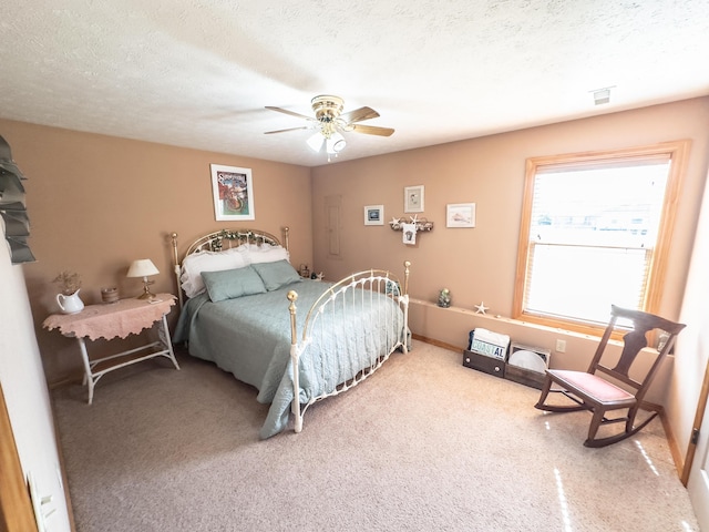 bedroom featuring ceiling fan, a textured ceiling, and carpet flooring