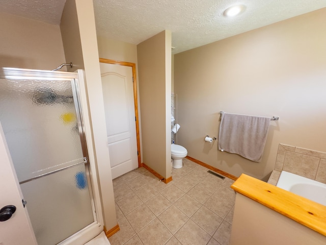 bathroom featuring tile patterned flooring, a textured ceiling, baseboards, and a shower stall