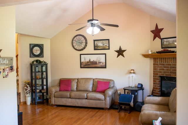 living room featuring lofted ceiling, a fireplace, ceiling fan, and wood finished floors