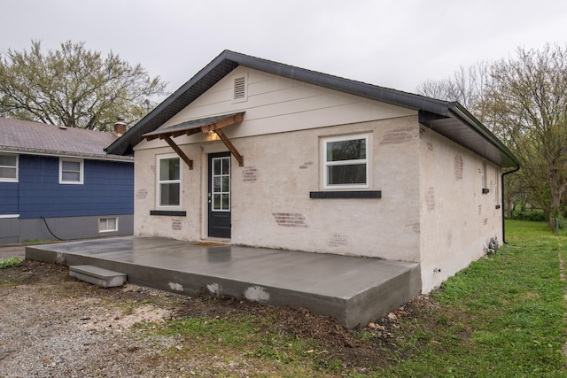 rear view of property with a patio area and stucco siding