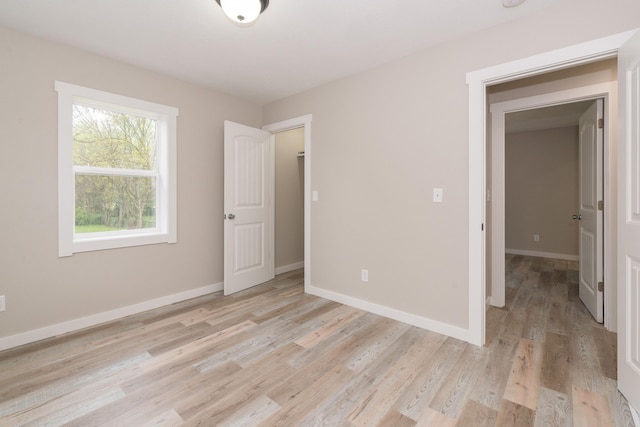 unfurnished bedroom with baseboards and light wood-style floors