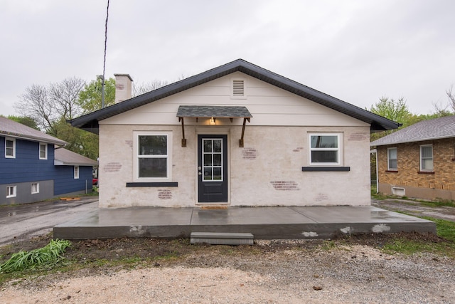 back of property featuring a chimney and a patio