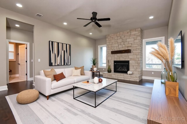 living room with wood finished floors, visible vents, baseboards, and a ceiling fan