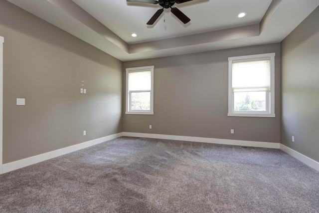 carpeted spare room featuring a tray ceiling, ceiling fan, baseboards, and recessed lighting