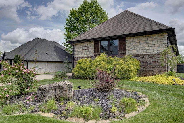 view of property exterior with a yard, stone siding, and roof with shingles