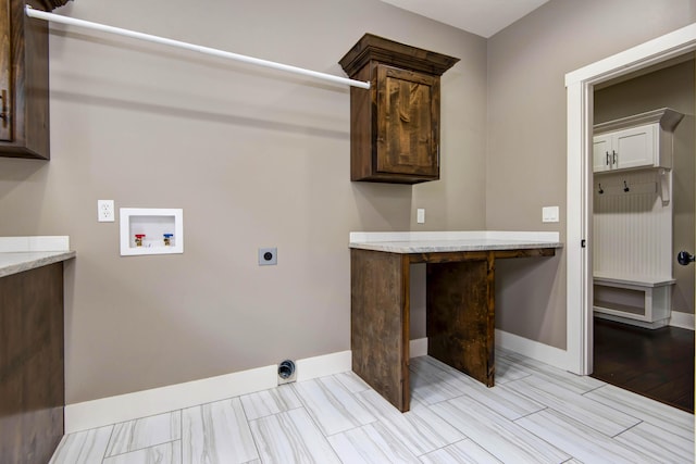 washroom with baseboards, washer hookup, hookup for an electric dryer, and cabinet space