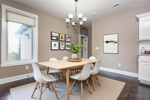 dining area featuring dark wood-style flooring, a notable chandelier, plenty of natural light, and visible vents