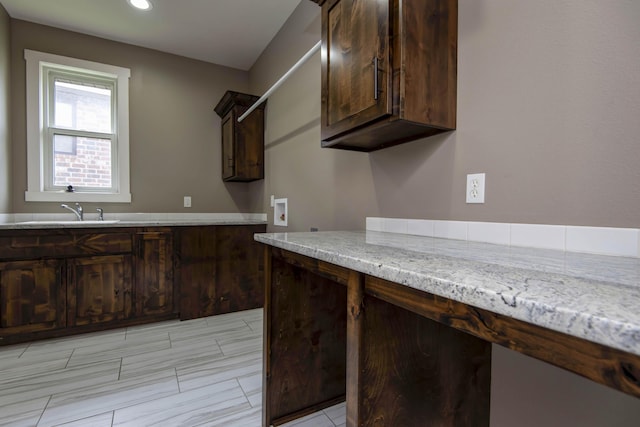 kitchen featuring recessed lighting, dark brown cabinets, and a sink