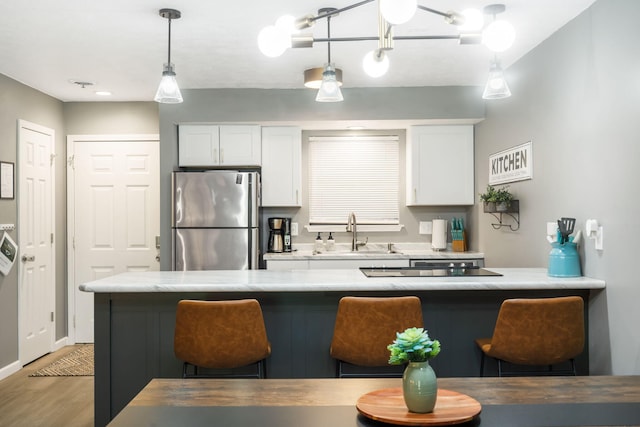 112 Overlook Dr Unit 2, Branson, MO 65616 - kitchen with freestanding refrigerator, a sink, a kitchen breakfast bar, light wood-style floors, and light countertops