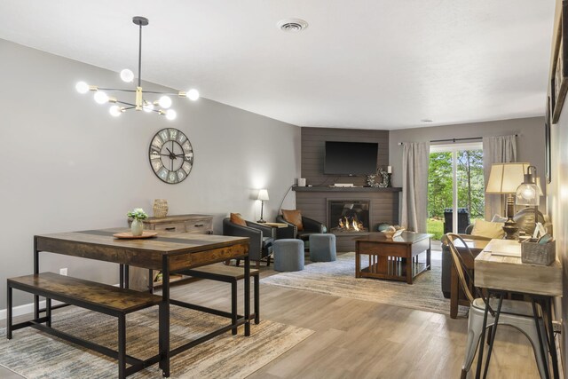 112 Overlook Dr Unit 2, Branson, MO 65616 - dining room featuring a chandelier, visible vents, light wood-style flooring, and a brick fireplace