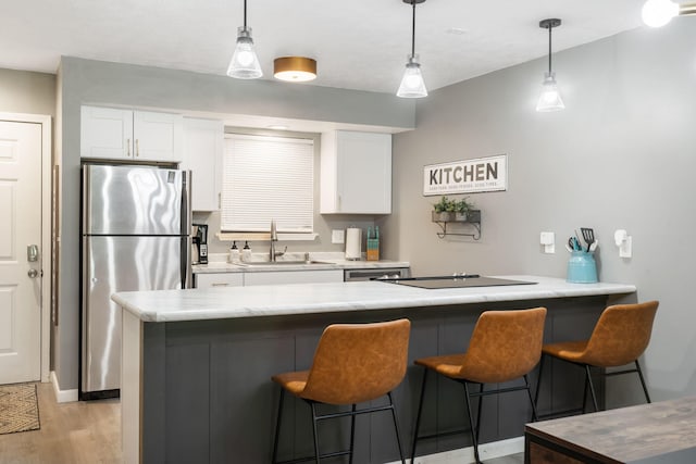 112 Overlook Dr Unit 2, Branson, MO 65616 - kitchen with a sink, a peninsula, black electric stovetop, freestanding refrigerator, and white cabinetry