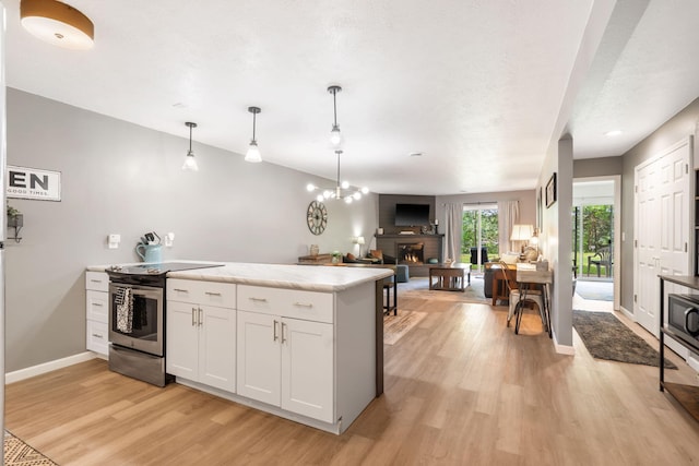 112 Overlook Dr Unit 2, Branson, MO 65616 - kitchen with open floor plan, electric stove, a lit fireplace, light wood-style floors, and white cabinets