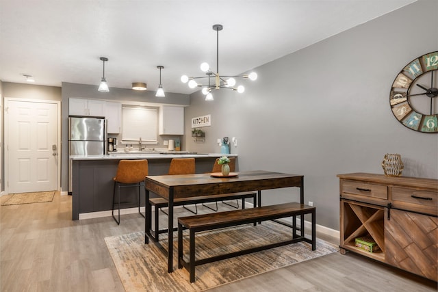 112 Overlook Dr Unit 2, Branson, MO 65616 - dining room with an inviting chandelier, light wood-type flooring, and baseboards