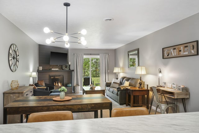 112 Overlook Dr Unit 2, Branson, MO 65616 - living room with a lit fireplace, a notable chandelier, baseboards, and visible vents