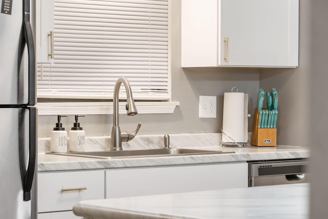 112 Overlook Dr Unit 2, Branson, MO 65616 - kitchen with freestanding refrigerator, white cabinetry, and a sink