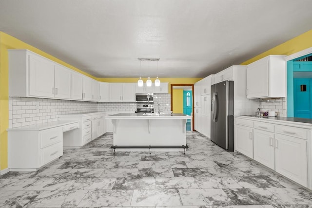 kitchen with white cabinetry, marble finish floor, light countertops, and stainless steel appliances