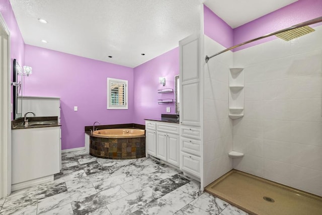 bathroom with marble finish floor, tiled shower, a garden tub, and vanity