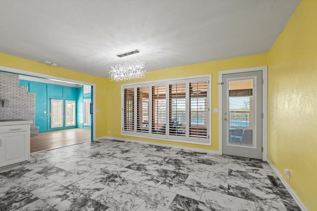unfurnished living room featuring plenty of natural light, visible vents, and marble finish floor