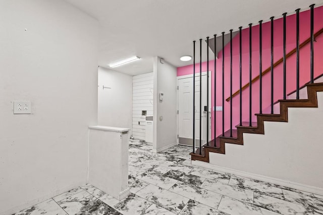 stairway with baseboards and marble finish floor