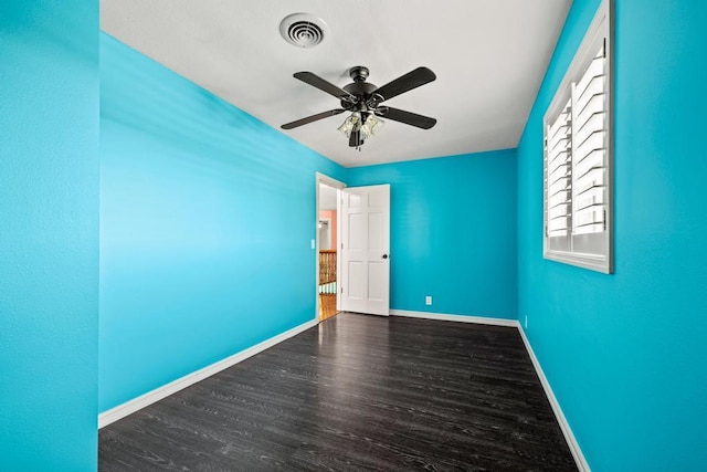 spare room featuring a ceiling fan, baseboards, visible vents, and wood finished floors