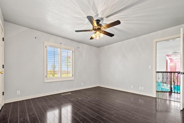 spare room featuring visible vents, wood finished floors, baseboards, and ceiling fan
