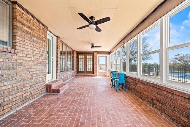 unfurnished sunroom with ceiling fan and french doors