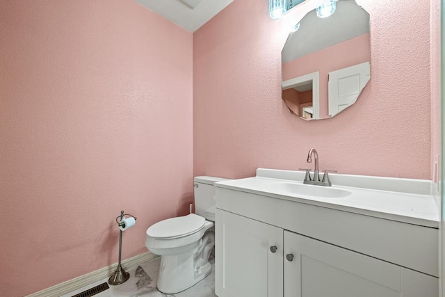 half bath with toilet, baseboards, marble finish floor, and vanity
