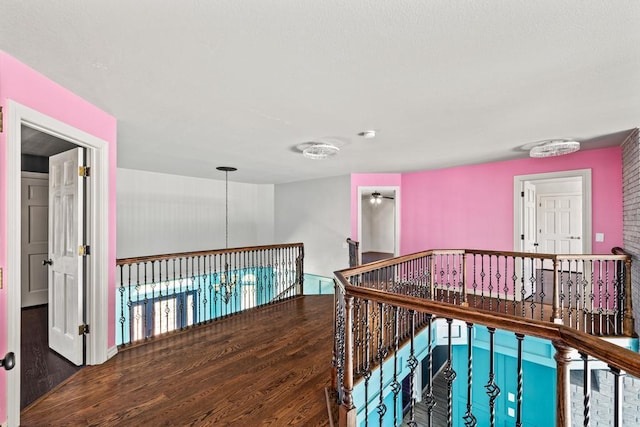hall featuring an upstairs landing and wood finished floors
