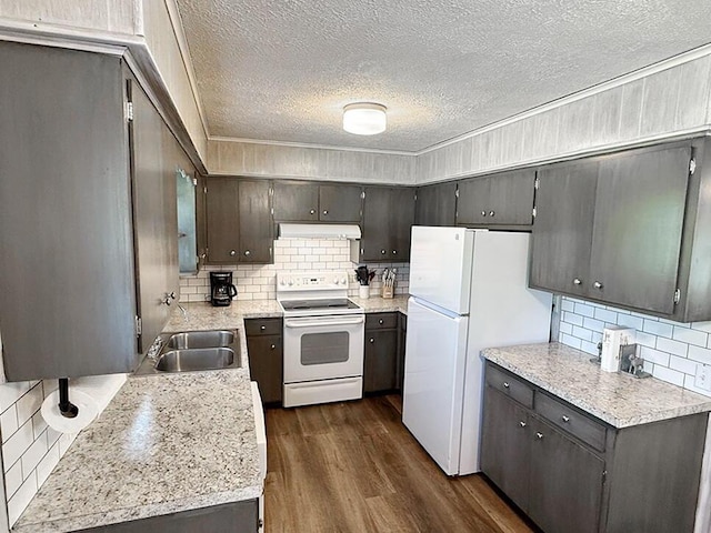 kitchen with a sink, white appliances, tasteful backsplash, a textured ceiling, and under cabinet range hood