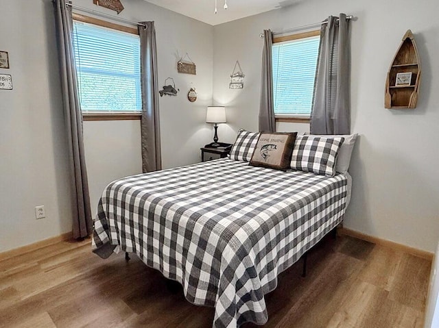 bedroom with wood finished floors and baseboards