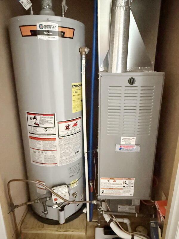 utility room featuring gas water heater and heating unit