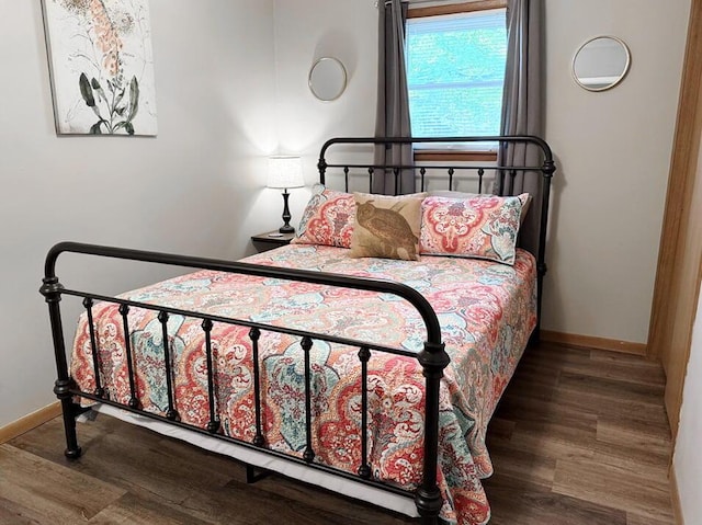 bedroom with baseboards and wood finished floors