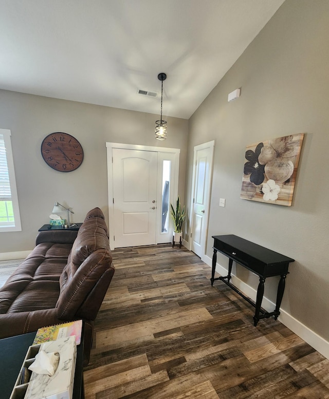 foyer featuring dark wood-style flooring, lofted ceiling, baseboards, and visible vents