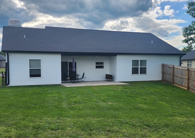 back of property featuring a yard, a shingled roof, a patio area, and fence