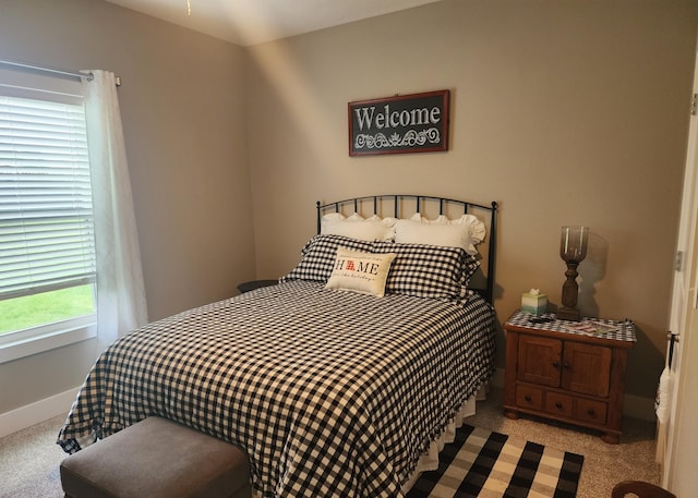 bedroom featuring light carpet and baseboards