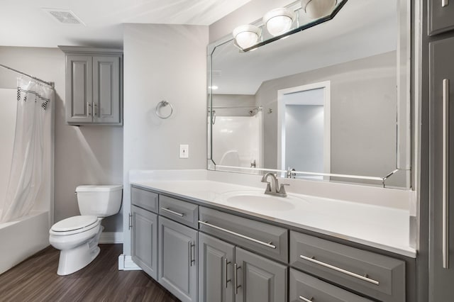 bathroom with toilet, shower / tub combo with curtain, visible vents, vanity, and wood finished floors