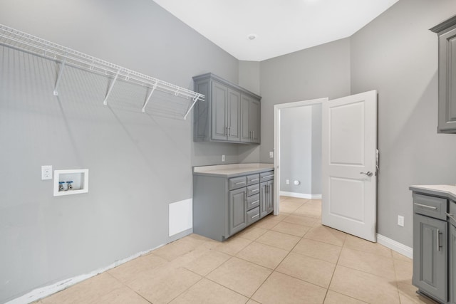 laundry room featuring baseboards, washer hookup, light tile patterned flooring, and cabinet space