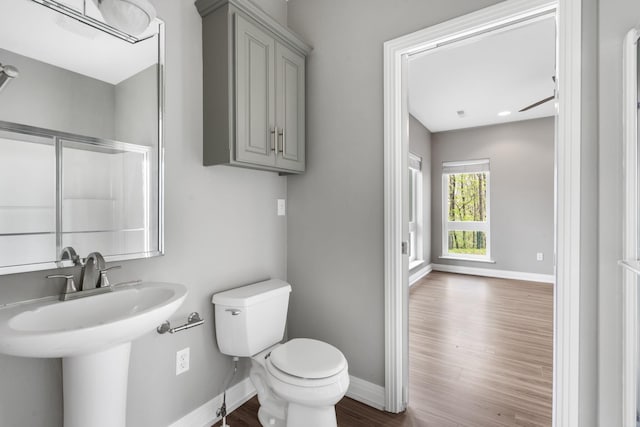 bathroom featuring baseboards, toilet, and wood finished floors