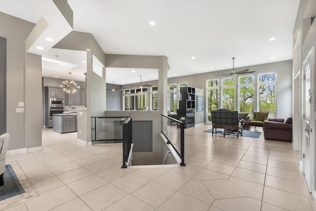 interior space featuring recessed lighting, ceiling fan with notable chandelier, open floor plan, stainless steel appliances, and gray cabinets
