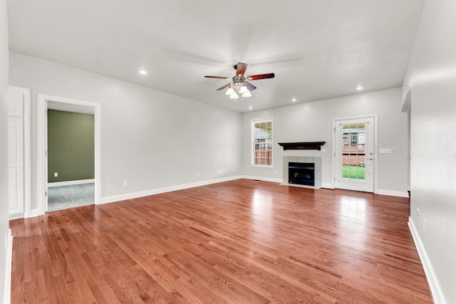 unfurnished living room with light wood-type flooring, a fireplace, a ceiling fan, and recessed lighting