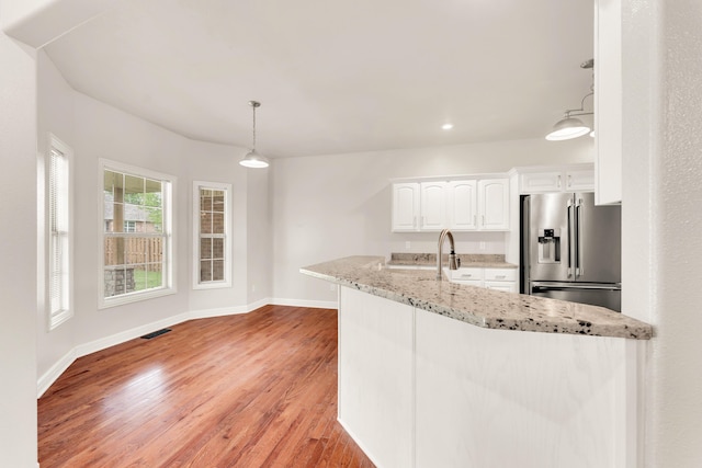 kitchen with stainless steel fridge with ice dispenser, light wood-type flooring, baseboards, and white cabinets