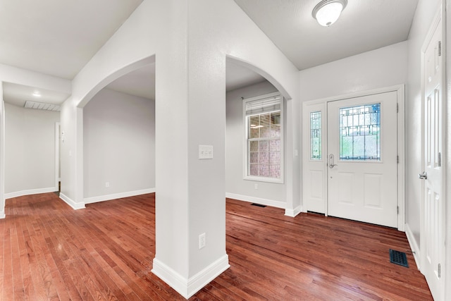 entryway featuring arched walkways, visible vents, and wood finished floors