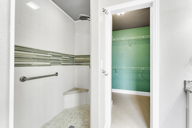full bath featuring a shower stall and a walk in closet