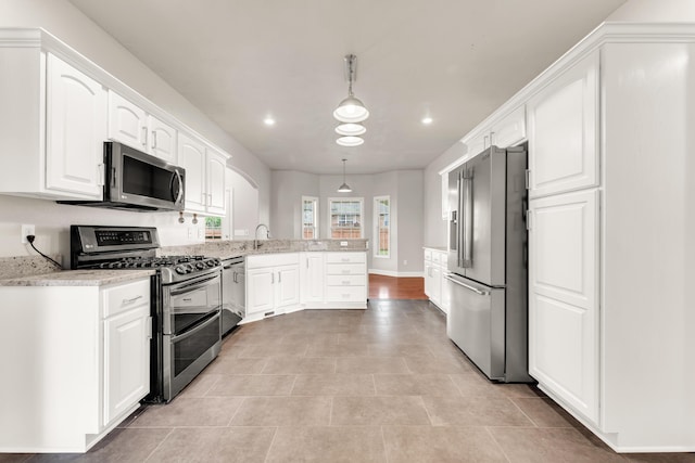 kitchen featuring decorative light fixtures, a sink, a peninsula, stainless steel appliances, and white cabinets