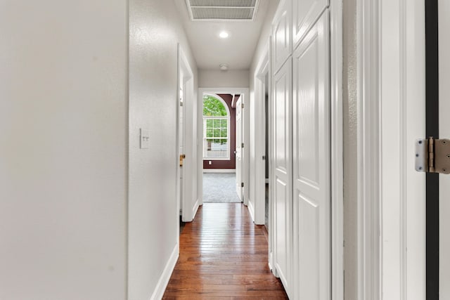 hallway with visible vents, baseboards, dark wood-type flooring, and recessed lighting
