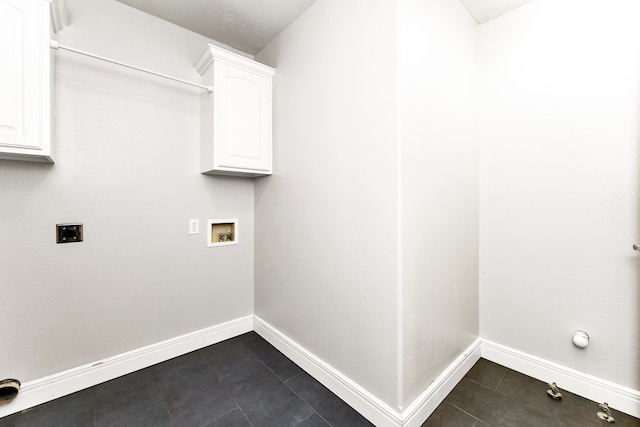 laundry room featuring cabinet space, dark tile patterned flooring, hookup for an electric dryer, hookup for a washing machine, and baseboards