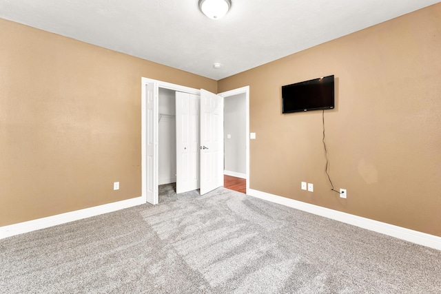 unfurnished bedroom featuring carpet flooring, baseboards, and a closet