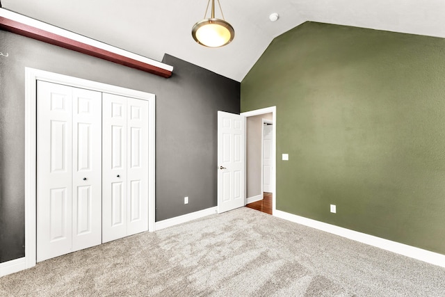 unfurnished bedroom with baseboards, carpet flooring, a closet, and high vaulted ceiling