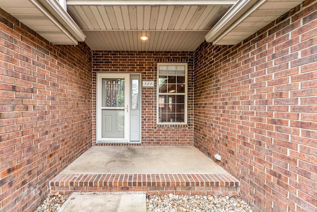 doorway to property featuring brick siding